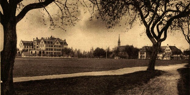 Schwarz-weiss Aufnahme von Neuendettelsau mit Kirchturm und Feld
