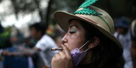 Eine Frau mit Hut raucht während einer Demo für die Legalisierung von Cannabis in Mexiko