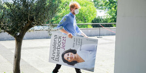 Ein Mann trägt nach der Vorstellung des Buches der grünen Kanzlerkandidatin Annalena Baerbock «Jetzt. Wie wir unser Land erneuern» ein Plakat des Buchdeckels davon