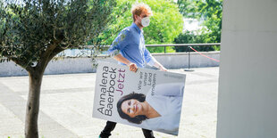 Ein Mann trägt nach der Vorstellung des Buches der grünen Kanzlerkandidatin Annalena Baerbock «Jetzt. Wie wir unser Land erneuern» ein Plakat des Buchdeckels davon