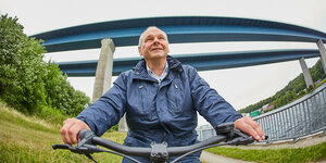 Mathias Stein - Mann auf Fahrrad vor Brücke