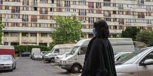 Verschleierte Frau vor Plattenbau im Pariser Vorort Clichy-sous-Bois