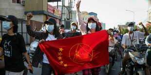 Demonstranten mt roter Flagge