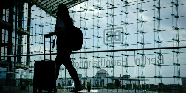 Eine Passantin schiebt ihren Koffer durch den Berliner Hauptbahnhof.