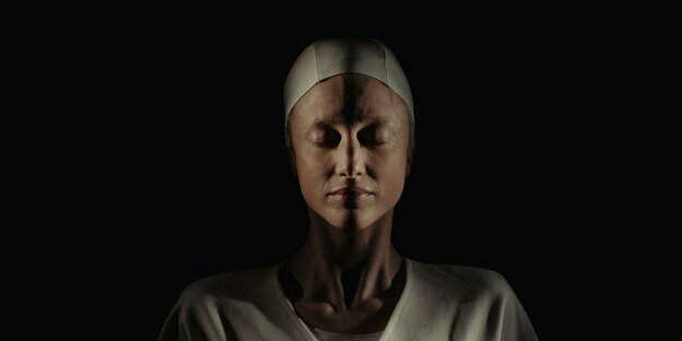 Tasya (Andrea Riseborough) liegt mit geschlossenen Augen im weißen Kittel auf dem Rücken. Tasya (Andrea Riseborough) liegt mit geschlossenen Augen im weißen Kittel auf dem Rücken.
