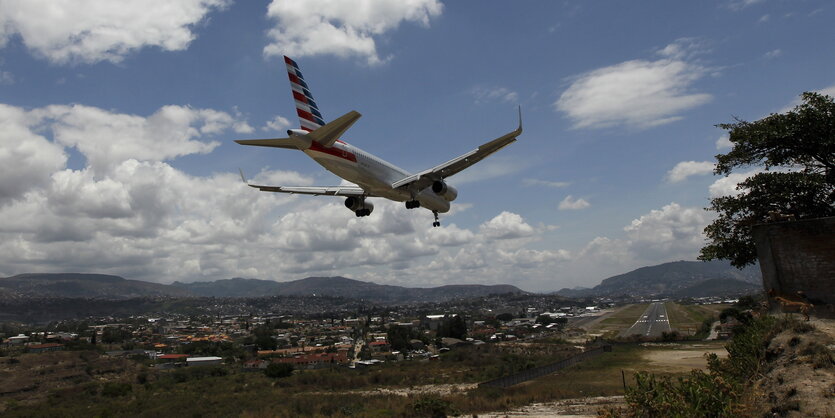 flugzeug im landeanflug auf eine kurze schmale Landebahn, Landschaft drumrum