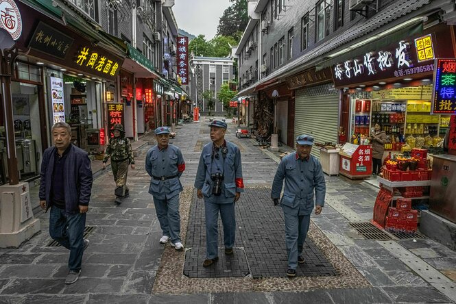 Männer gehen in Uniformen der Roten Armee durch eine Verkaufsstraße