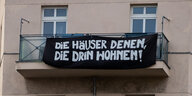 Transparent an einem Hausbalkon: "Die Häuser denen, die drin wohnen"