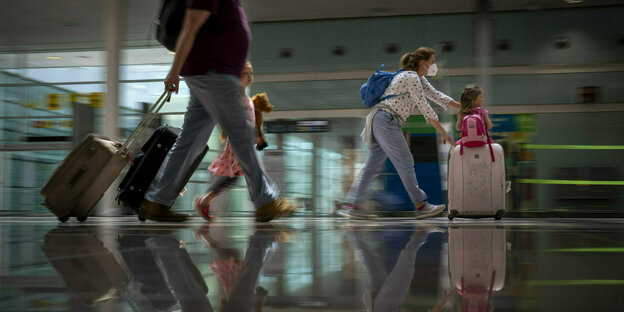 Eine Familie mit Rollkoffern am Flughafen