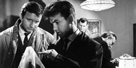 Szene aus „Pension Boulanka“ (1964): Zwei Kommissare untersuchen ein Taschentuch