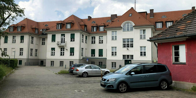 Auf der Rückseite des ehemaligen des früheren Kaiser-Wilhelm-Instituts stehen drei PKW