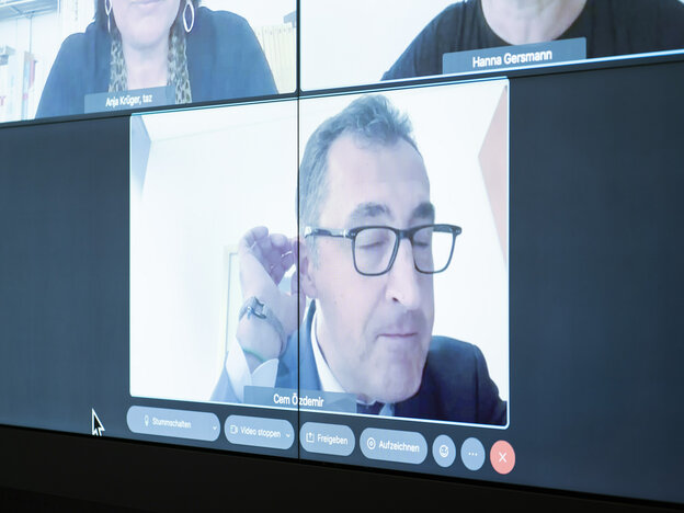 Cem Oezdemirs Gesicht auf einem Monitor