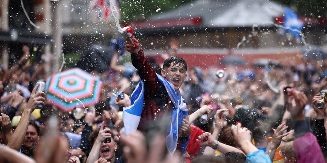 Schottische Fans feiern wild und spritzen mit Bier um sich vor dem Spiel England gegen Schottland in der Lononer Innenstadt