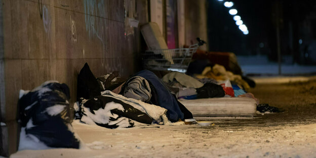 Obdachlose Menschen schlafen im Winter unter einer Brücke