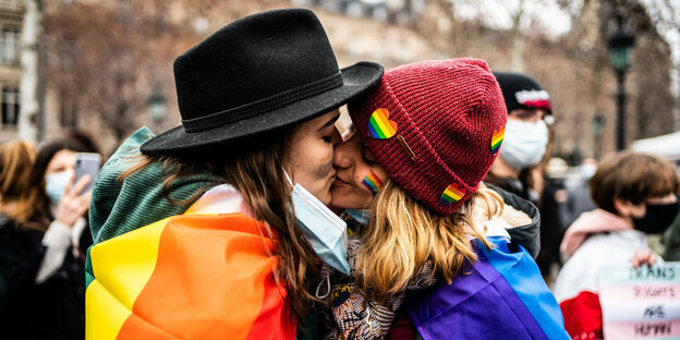 Zwei junge Frauen küssen sich auf einer Demonstration in Paris