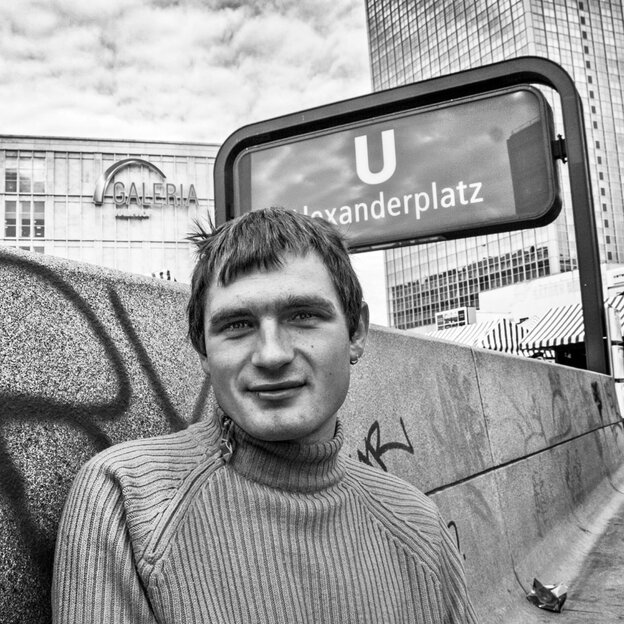 Porträt eines jungen Mannes mit Rollkragenpullover vor einem U-Bahnhofsschild Porträt eines jungen Mannes mit Rollkragenpullover vor einem U-Bahnhofsschild
