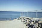 Blick auf das Meer von Ceuta aus, eine Grenzanlage teilt das Foto