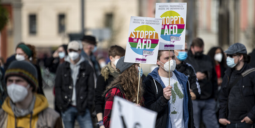 Menschen halten Schilder mit der Aufschrift "Stoppt die AfD" hoch