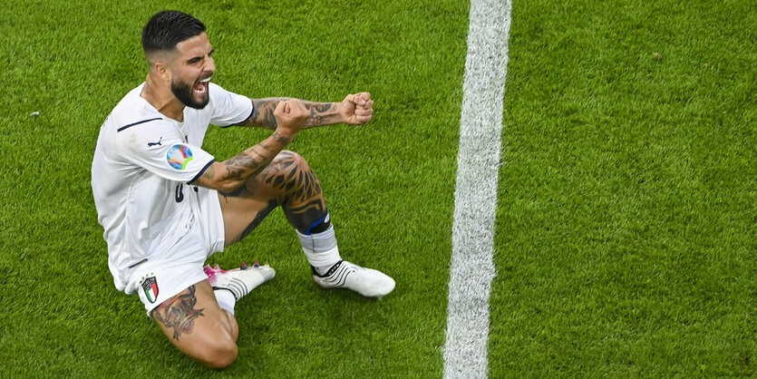 Italiens Lorenzo Insigne sitzt jubelnd die Fäuste ballend auf dem Rasen