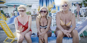 Drei ältere blonde Damen sitzen an einem italienischen Strand
