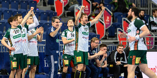 Handballer jubeln am Rand des Spielfeldes