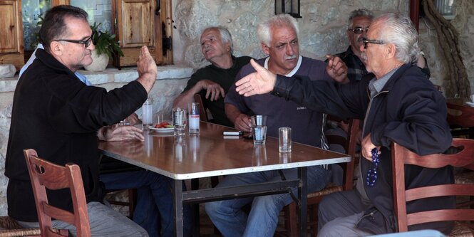 Männer sitzen an einem Tisch in einem Cafe