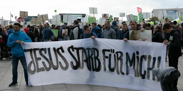 Demonstranten tragen ein Transparent mit der Aufschrift "Jesus starb für mich"