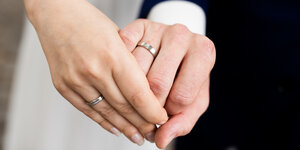 Die Hände eines frisch vermählten Brautpaares.