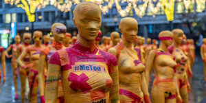 Installation mit 222 weibliche Schaufenserpuppen, in oranges Flatterband gewickelt, mit Slogans, sollen als Aufruf gegen Gewalt aller Art gegen Frauen aufrufen