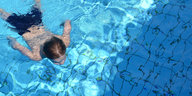 Ein Junge taucht im Pool