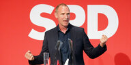 Frank Ullrich, Spitzenkandidat der SPD für die Bundestagswahl in Südthüringen, spricht auf einer Bühne - im Hintergrund das SPD Logo