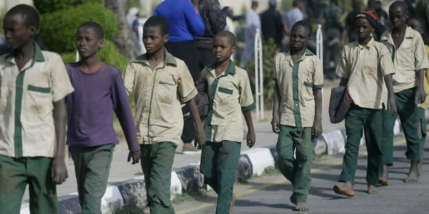 Eine Gruppe von Schuljungen wird nach ihrer Freilassung nach ihrer Entführung von nigerianischen Militärs und Beamten eskortiert