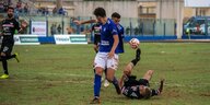 Szene aus italienischen Amateurfußball, ein Spieler versucht auf dem Rücken liegend noch den Ball zu spielen