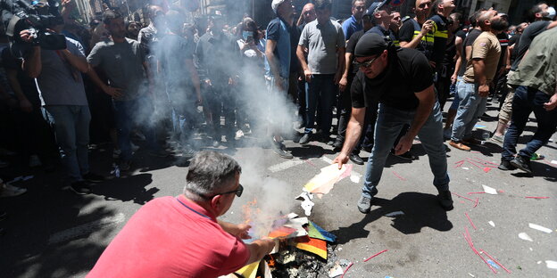 Männer verbrennen eine Regenbogenfahne