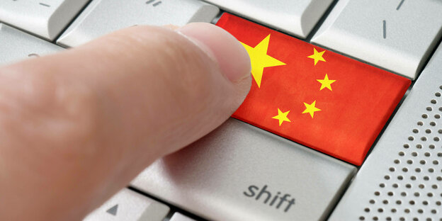 Finger tippt auf Tastatur mit Chinesischer Flagge