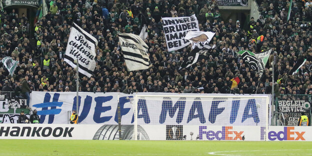 Fans hinter einem Transparent mit der Aufschrift "Uefa-Mafia"