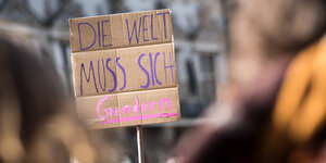 Ein Schild mit der Aufschrift "Die Welt muss sich gendern".