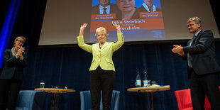 Erika Steinbach steht auf einem Podium und wird von Alice Weidel und Jörg Meuthen beklatscht.