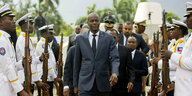 Haitis Präsident Jovenel Moïse läuft mit Gefolge zwischen Gardisten mit Gewehren