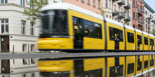 Eine Straßenbahn spiegelt sich in einer Regenpfütze