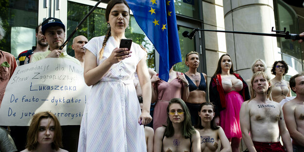Entkleidete Protestierende mit Firmennamen auf dem Körper vor der EU-Vertretung in Warschau