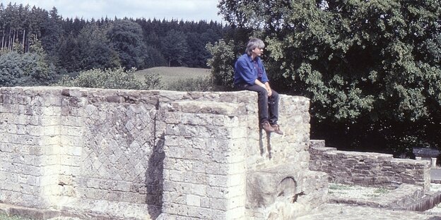 taz-Redakteur Klaus HIllenbrand sitzt auf einer Mauer