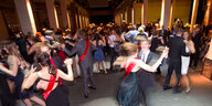 Junge Menschen feiern und tanzen auf einem Abiball in einer gro0en Halle.