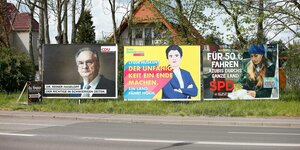 Drei Wahlplakate stehen auf einem Grünstreifen neben einer Straße. Links von der CDU, in der Mitte von der FDP und ganz rechts von der SPD.
