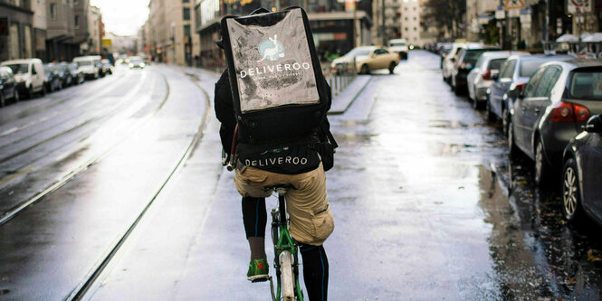 Fahrradkurier mit Tasche von hinten