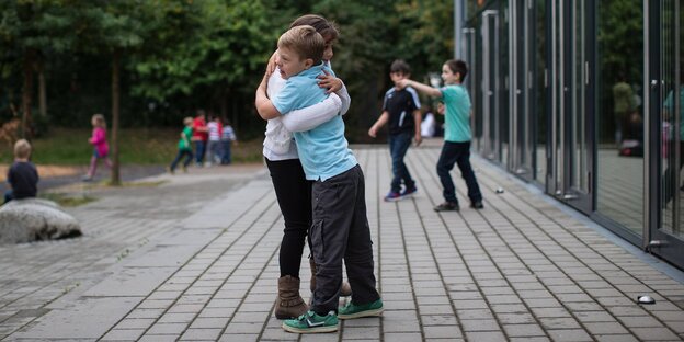 Junge mit Down-Syndrom umarmt Mädchen