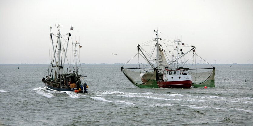 zwei Krabbenkutter auf grauer See vor grauem Himmel