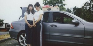 Zwei junge Frauen vor einem Auto: Vorabfoto zur Inszenierung „Die fliegenden Eier von Sarajewo“