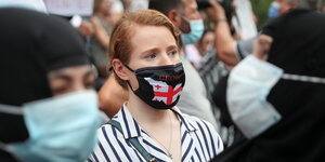 Eine Frau trägt eine Mund-Nasen-Maske auf einer Demonstration in Tiflis, Georgien