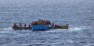 Retter auf Schlauchbooten helfen Flüchtlingen